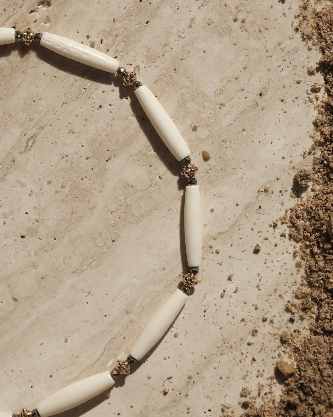 Détail du collier perles d’os et pyrite dorée à l’or fin – création artisanale Atelier Veda