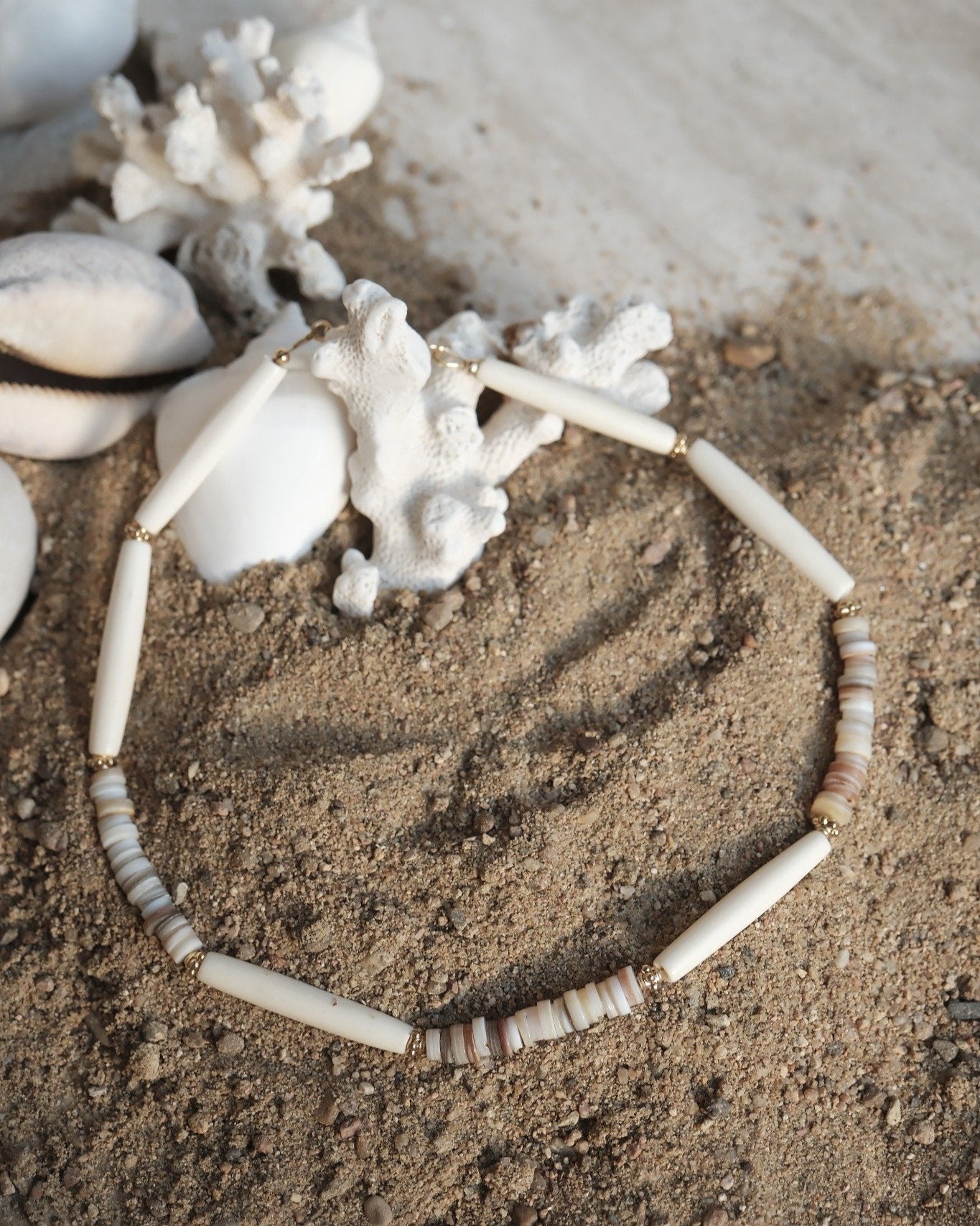 Bijou en os et coquillages sur sable et corail – création artisanale Atelier Veda